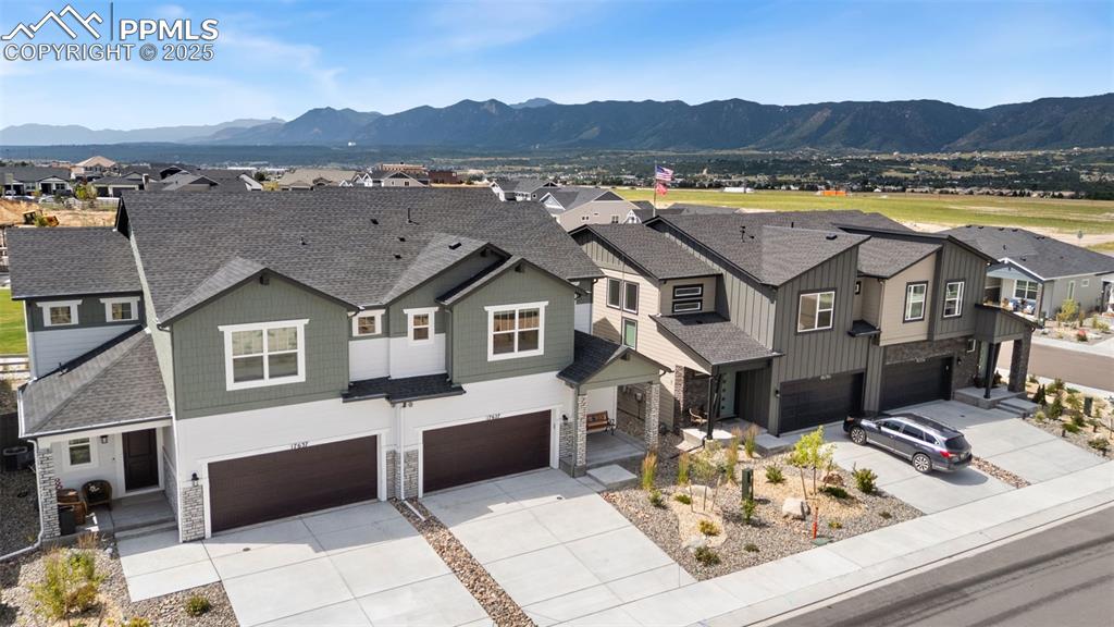 Image 37 of 50: View of front of house featuring a residential view, stone siding, roof wit