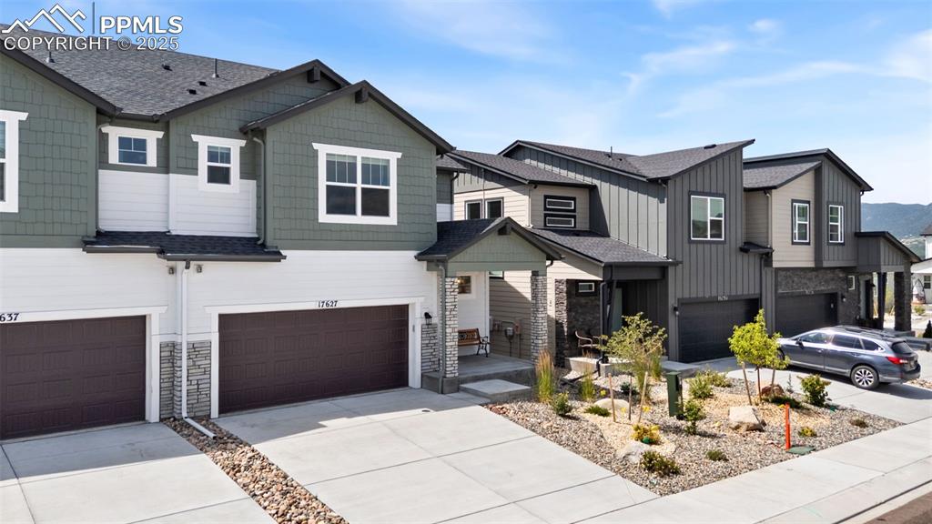 Image 39 of 50: View of front facade with concrete driveway, an attached garage, and a shin