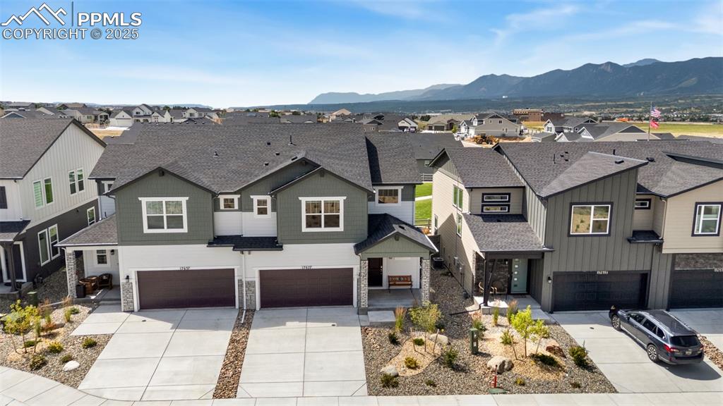 Image 40 of 50: View of front of house featuring a residential view, stone siding, and a ga