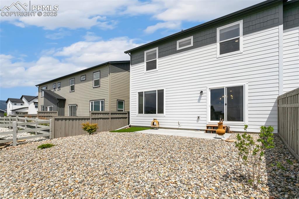 Image 41 of 50: Back of property featuring a fenced backyard and a patio area