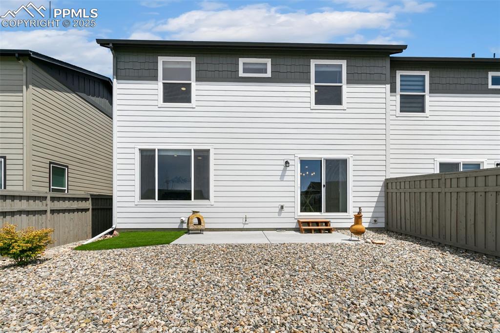 Image 42 of 50: Back of house with a fenced backyard and a patio