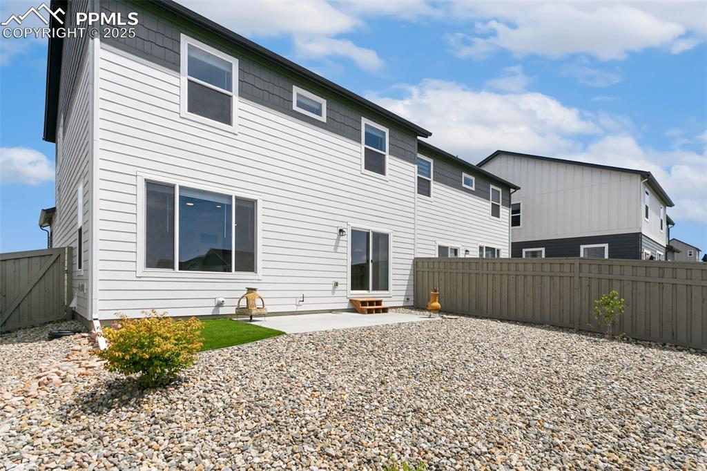 Image 44 of 50: Rear view of house featuring a fenced backyard and a patio area