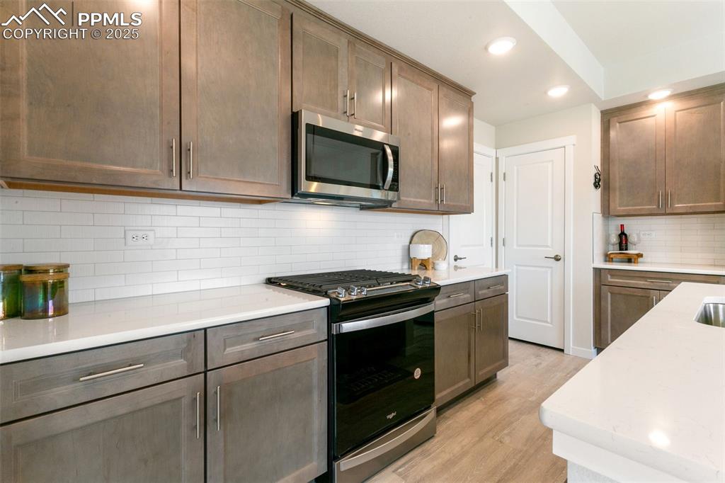 Image 6 of 50: Kitchen featuring stainless steel appliances, light wood-style floors, rece