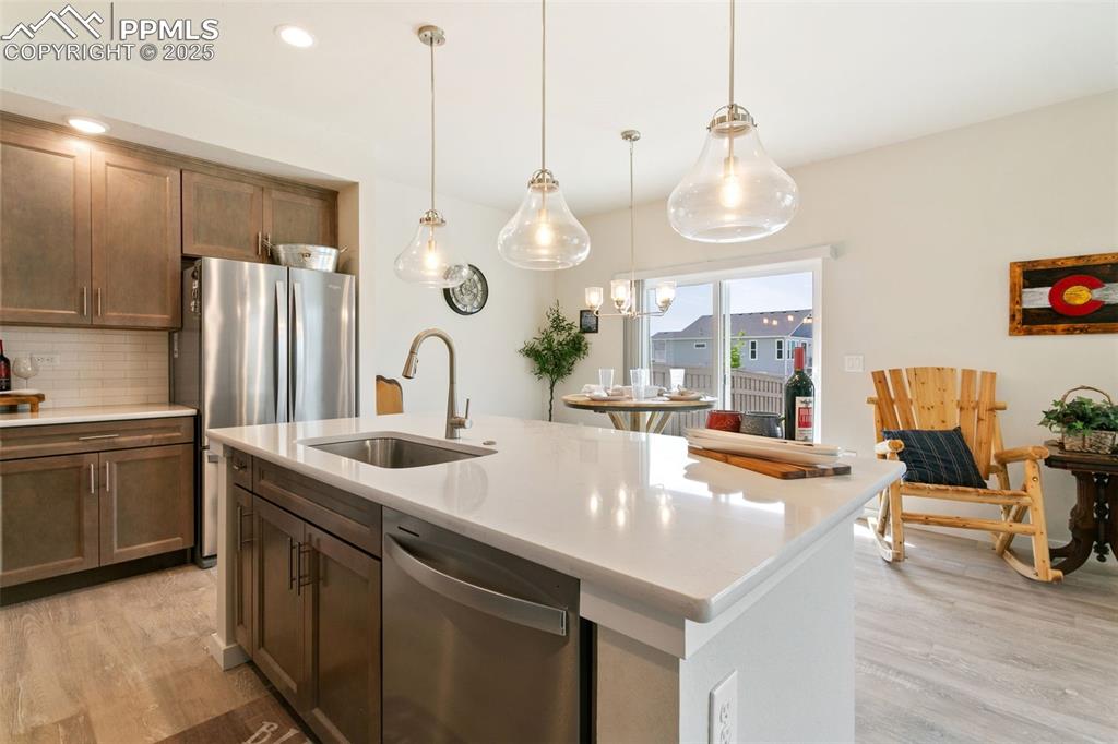 Image 7 of 50: Kitchen with stainless steel appliances, light wood-style flooring, tastefu