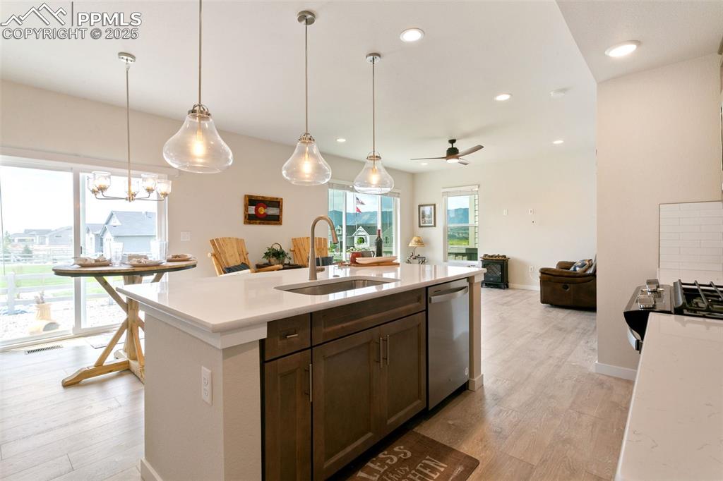 Image 8 of 50: Kitchen featuring light wood finished floors, ceiling fan, light countertop
