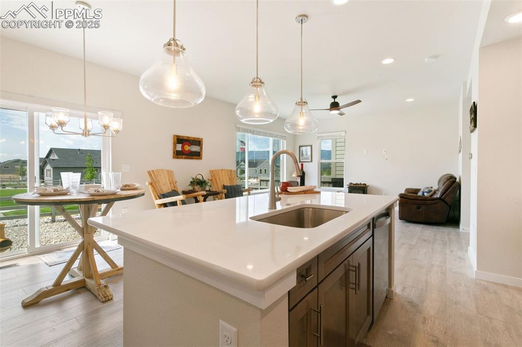 Image 9 of 50: Kitchen with light wood-style flooring, recessed lighting, light countertop