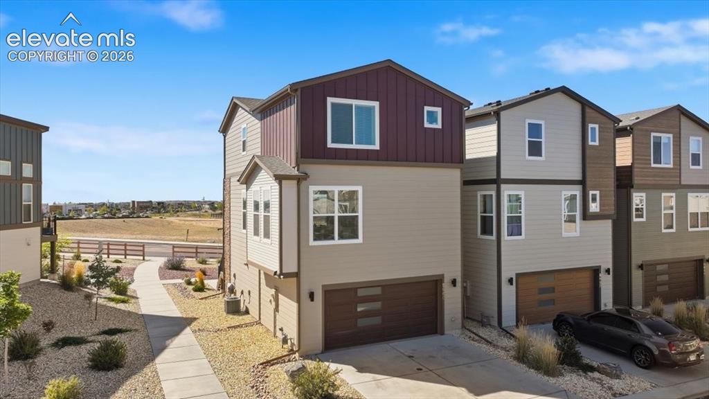 Image 3 of 36: Back of the home and entrance to Garage and guest parking close by.