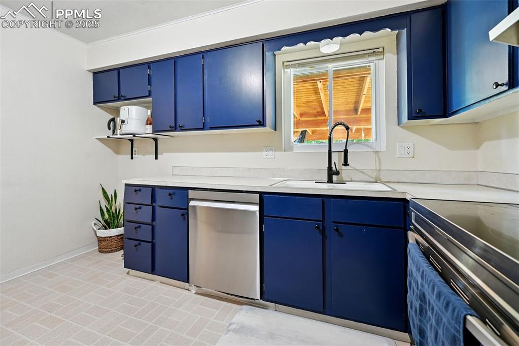 Image 10 of 31: Kitchen featuring appliances with stainless steel finishes, blue cabinets,