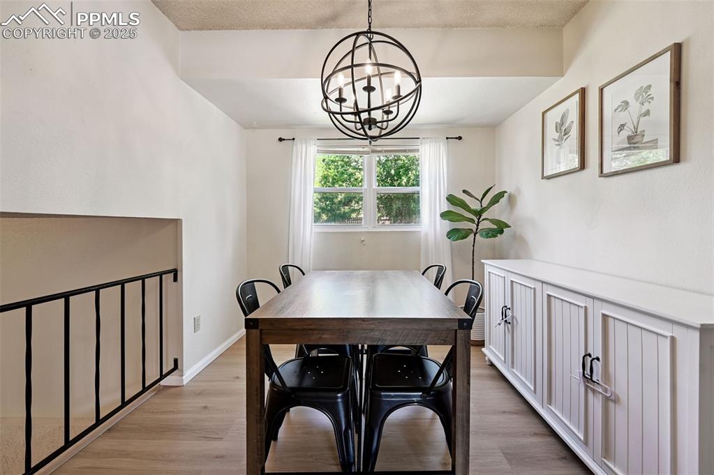 Image 11 of 31: Dining space with a chandelier and light wood finished floors
