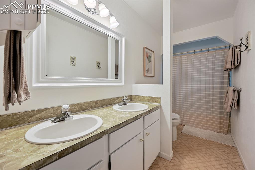 Image 15 of 31: Upper Level Full bathroom featuring double vanity, shower/tub