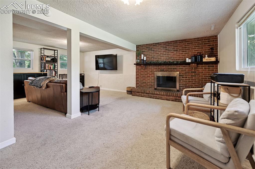 Image 16 of 31: Carpeted living room with a textured ceiling, healthy amount of natural lig