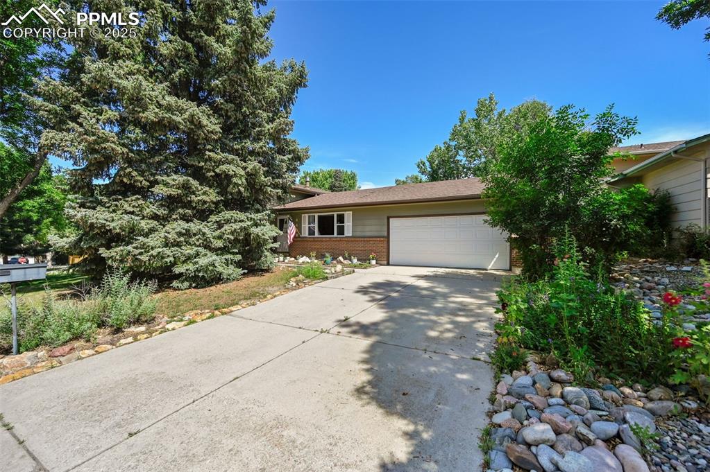 Image 2 of 31: View of front of house with brick siding, concrete driveway, and an attache