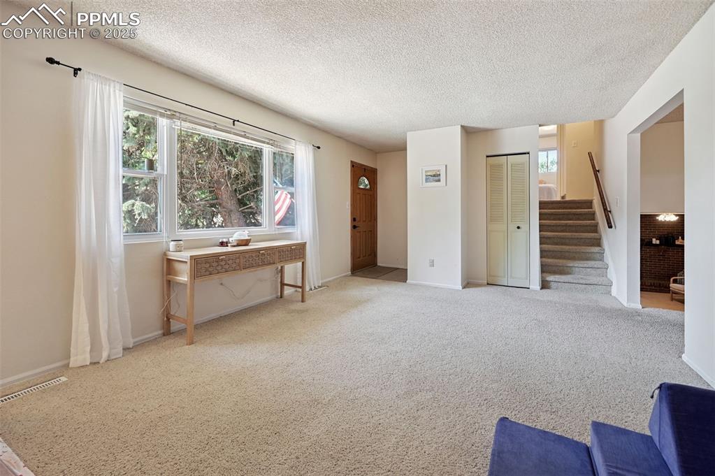 Image 4 of 31: Living room featuring stairway, healthy amount of natural light, a textured