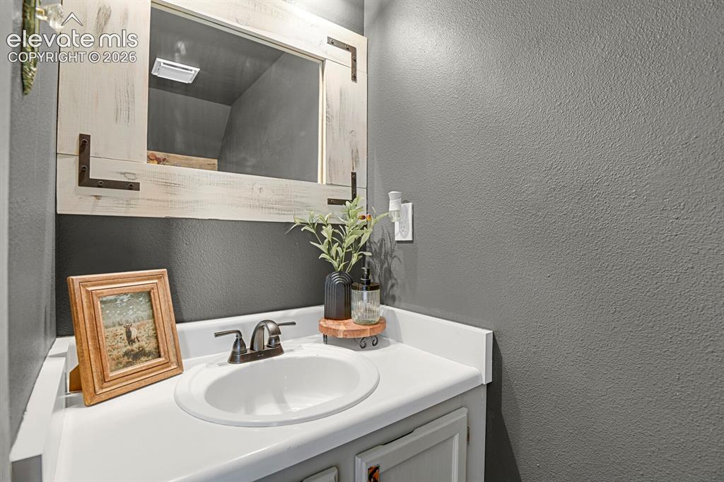Image 15 of 32: Vanity with an integrated sink, dark bronze-finish faucet, and a decorative