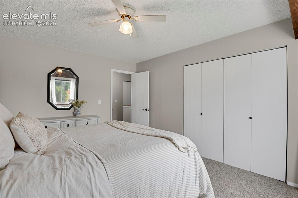 Image 17 of 32: Ceiling fan with light fixture, light gray wall paint, octagonal wall mirro