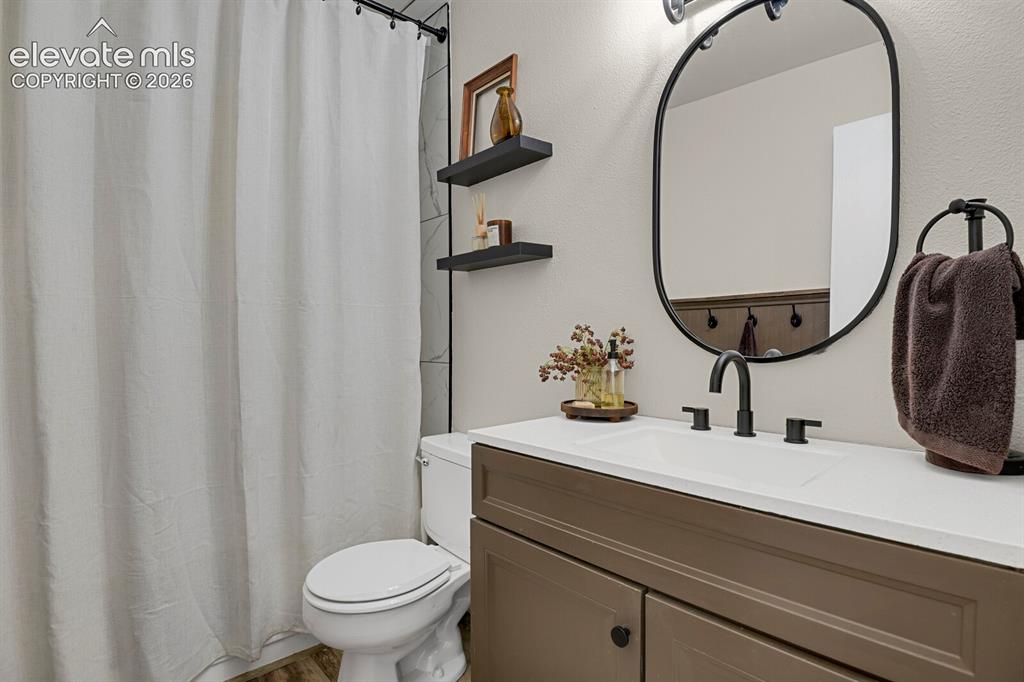 Image 18 of 32: Vanity with a white countertop and integrated sink, matte black faucet, ova