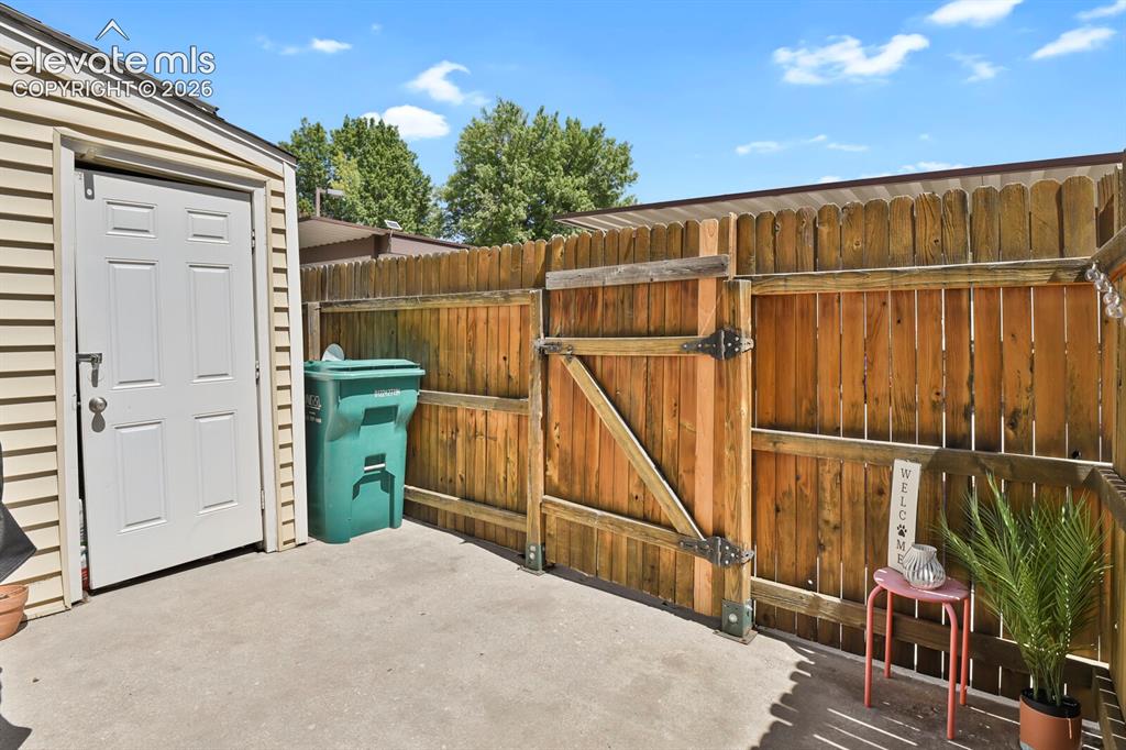 Image 21 of 32: Private outdoor area featuring concrete paving, a wood privacy fence, and a