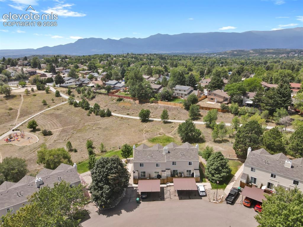 Image 29 of 32: Townhome community with mountain scenery, multiple carports, and nearby par