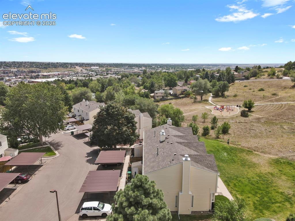 Image 32 of 32: Community setting featuring buildings with pitched roofs, adjacent open gre