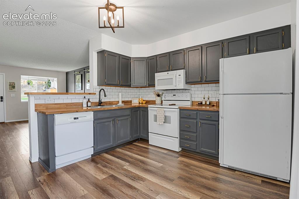 Image 9 of 32: L-shaped kitchen with wood-finish flooring, grey cabinetry, wood-look count