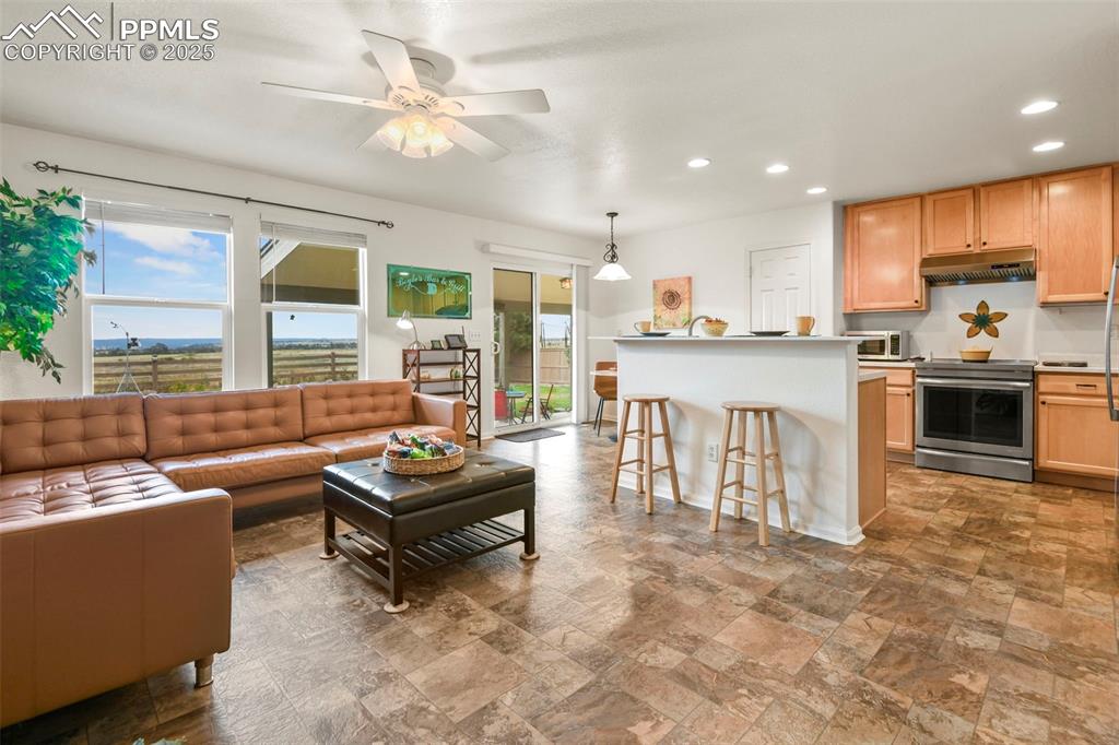 Image 10 of 32: Living area featuring recessed lighting, stone finish flooring, and ceiling