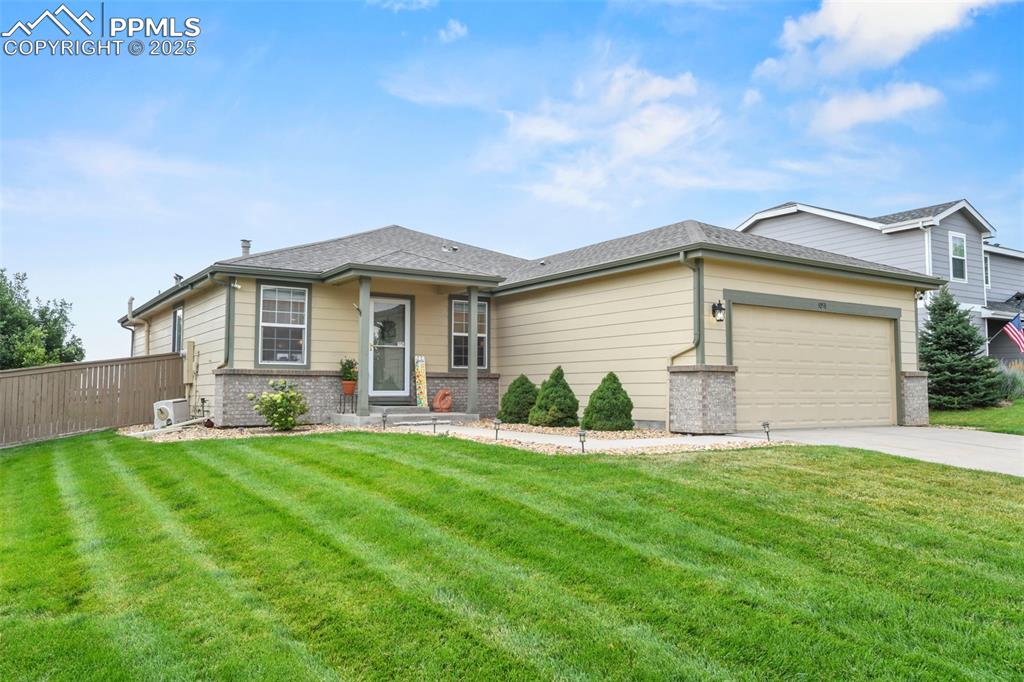 Image 2 of 32: View of front of home with brick siding, an attached garage, concrete drive