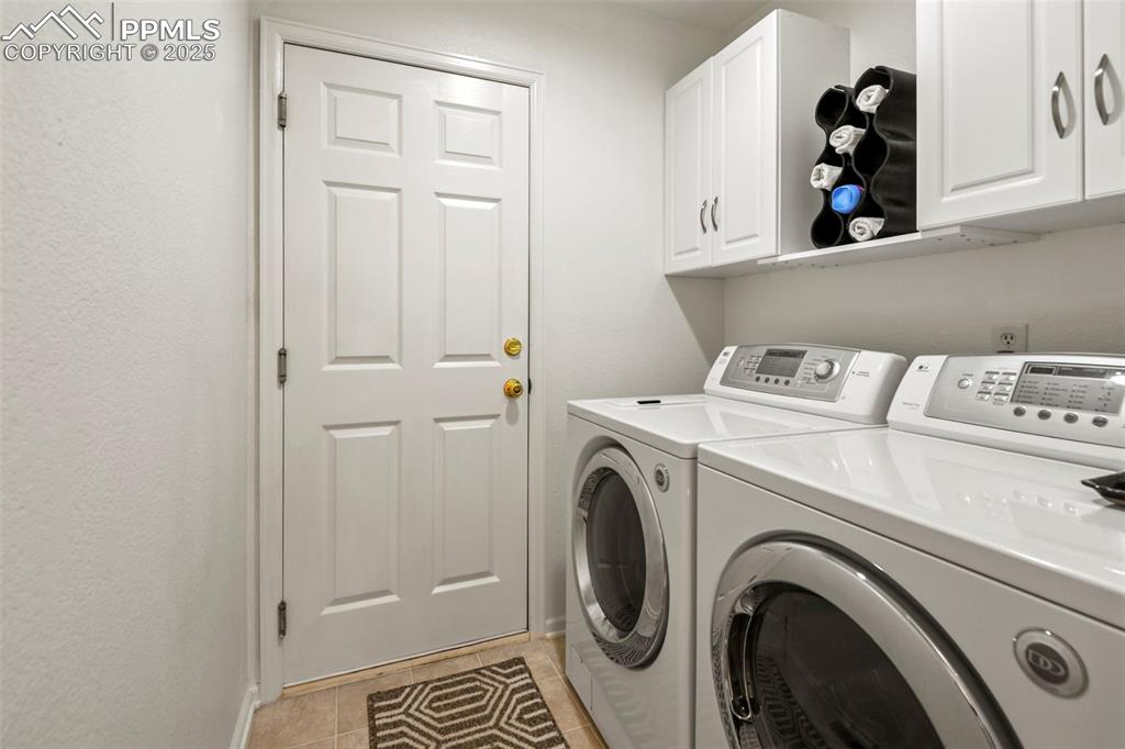 Image 20 of 32: Washroom with separate washer and dryer, light tile patterned flooring, and