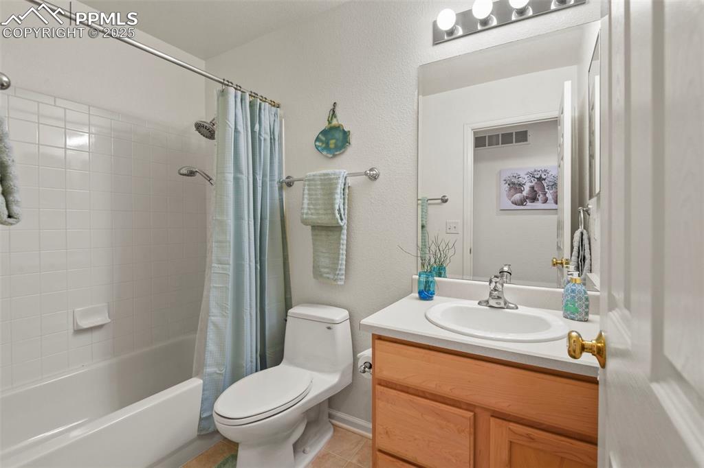 Image 21 of 32: Bathroom featuring vanity, shower / bath combination with curtain, a textur