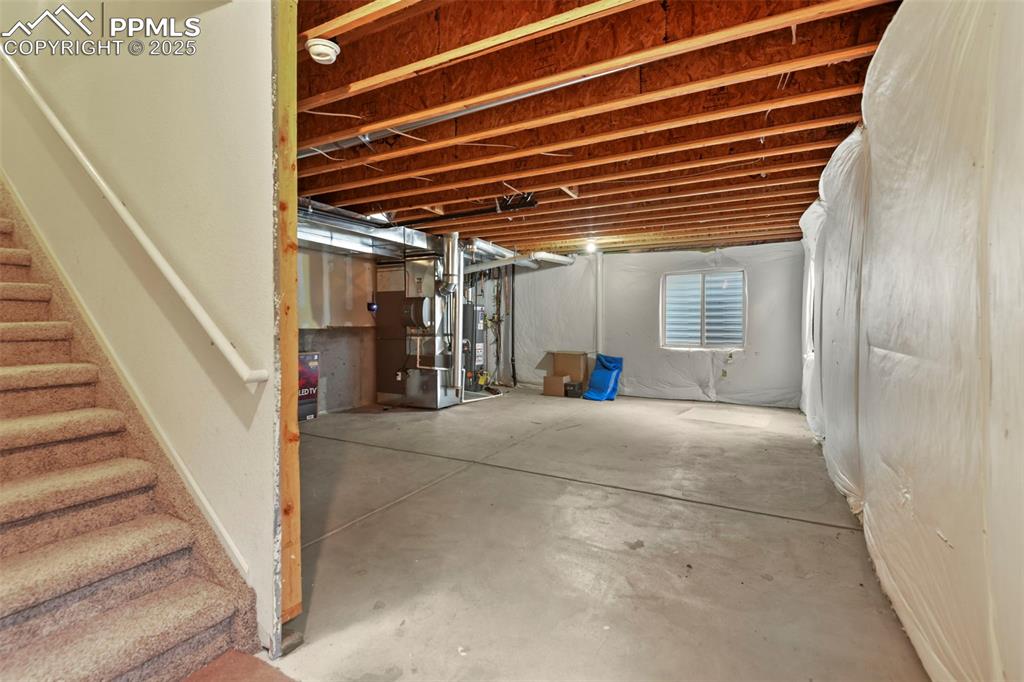 Image 22 of 32: Below grade area featuring heating unit and water heater