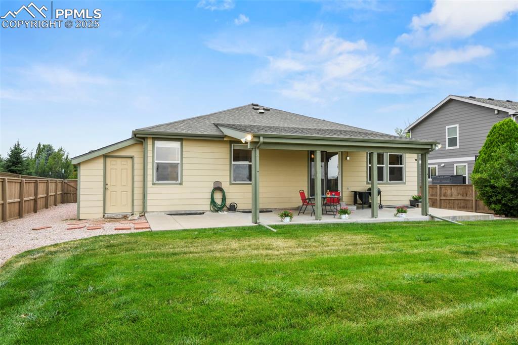 Image 26 of 32: Back of property featuring a fenced backyard, a patio area, and roof with s