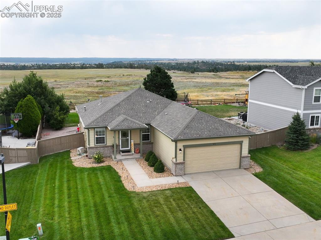 Image 30 of 32: Ranch-style house featuring roof with shingles, a garage, driveway, brick s