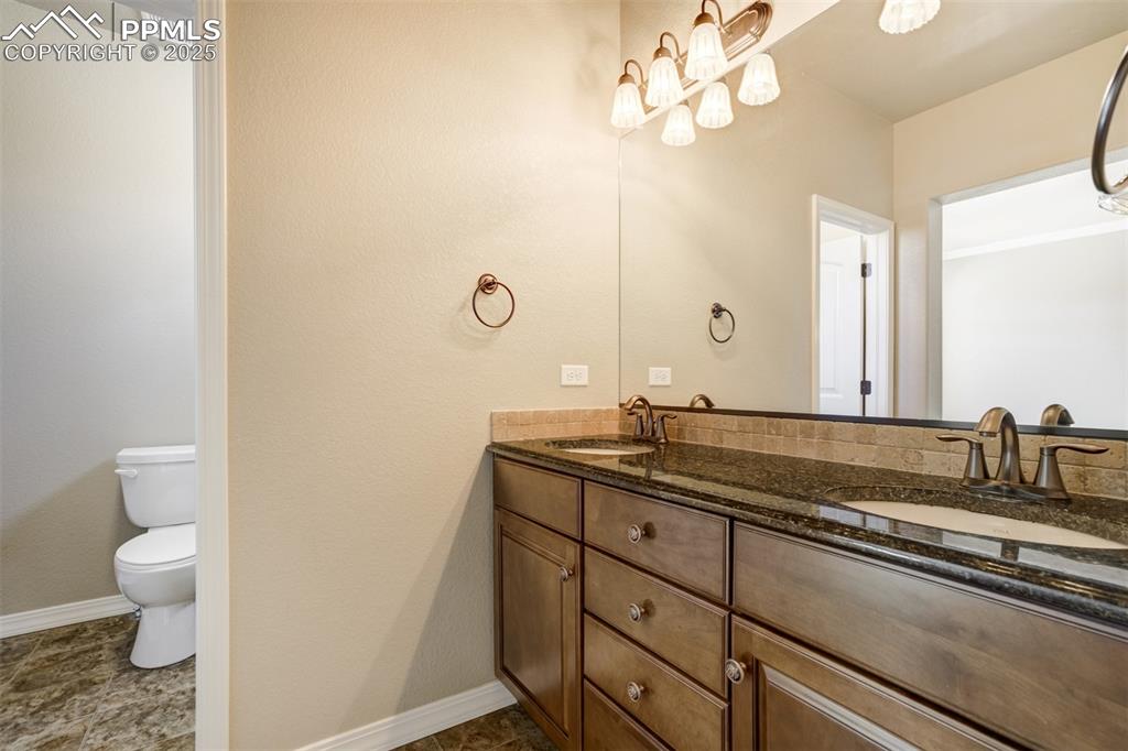 Image 14 of 36: Full bathroom with double vanity and toilet