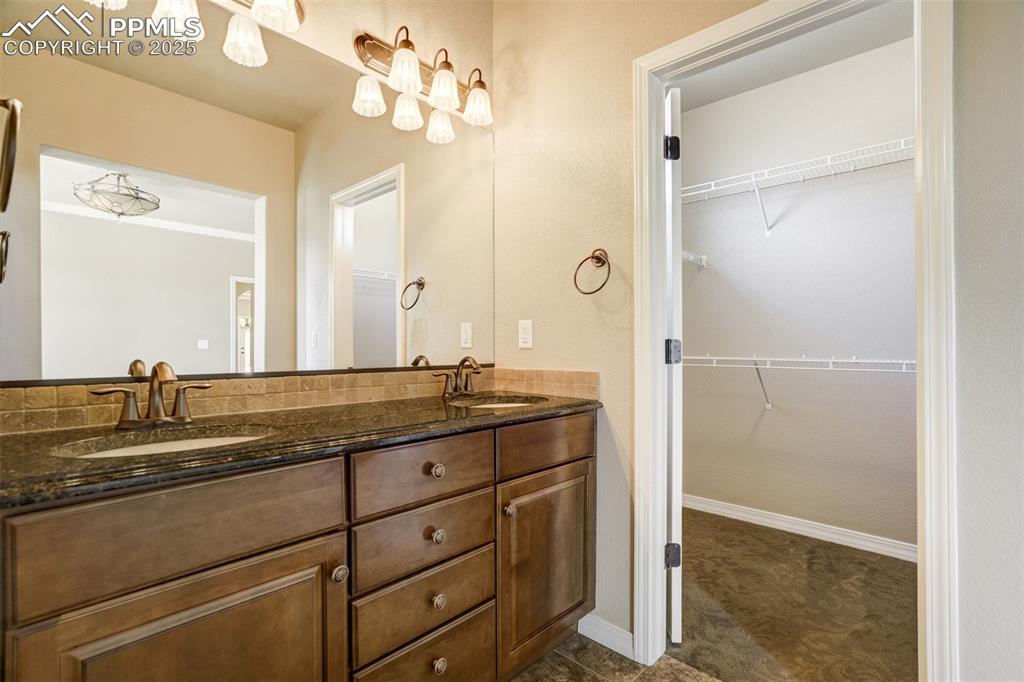 Image 15 of 36: Bathroom with double vanity and a walk in closet