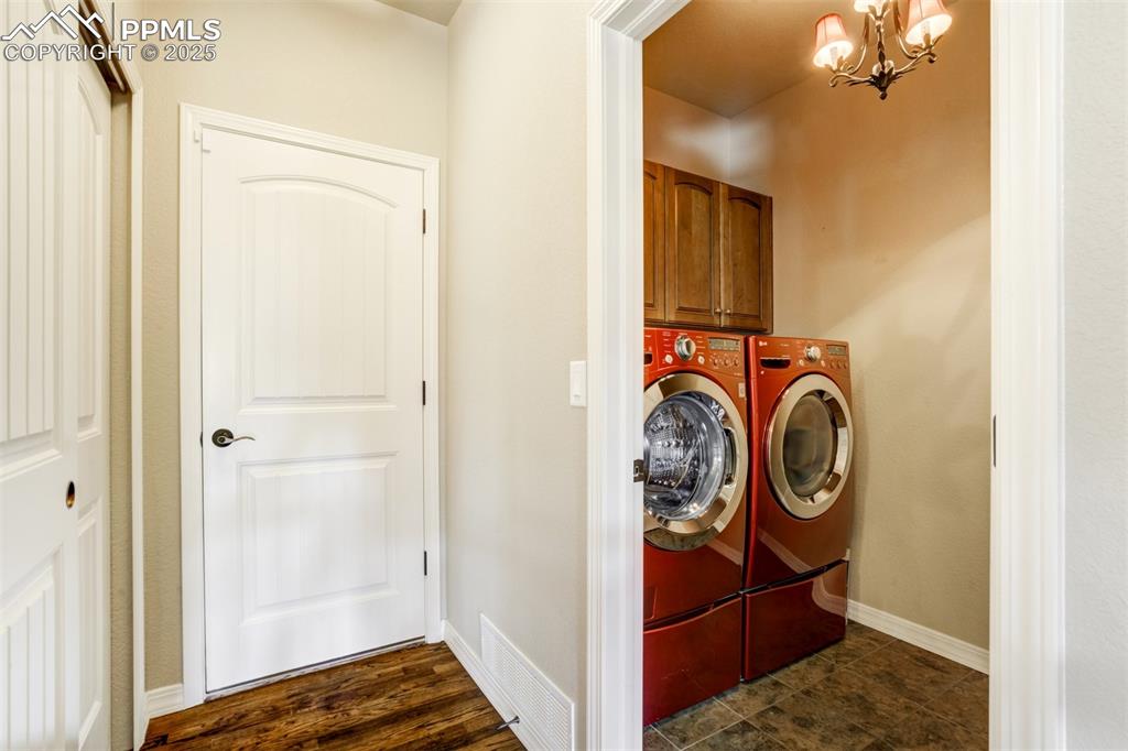 Image 19 of 36: Laundry room with cabinet space, independent washer and dryer, and a chande