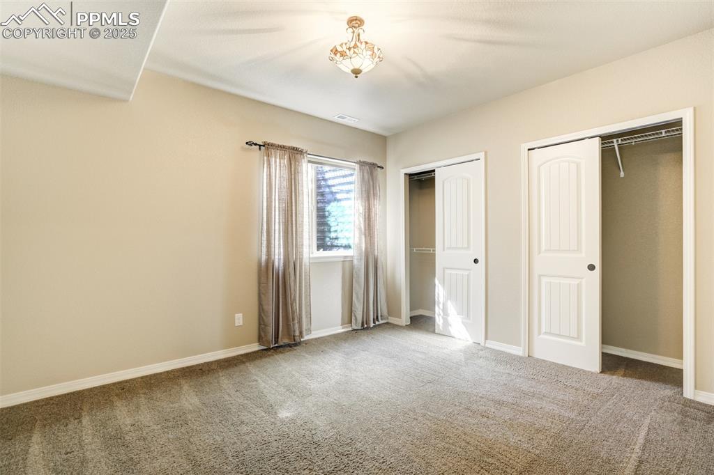 Image 24 of 36: Unfurnished bedroom featuring multiple closets and carpet