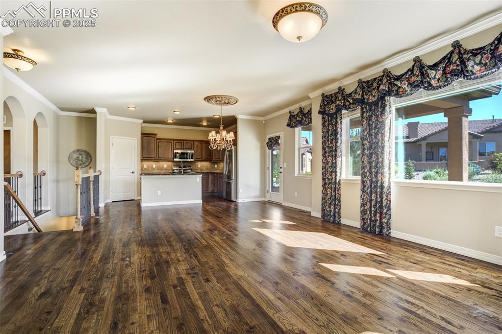 Image 4 of 36: Unfurnished living room featuring a chandelier, dark wood-type flooring, an