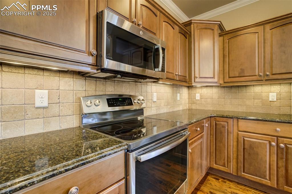 Image 8 of 36: Kitchen with appliances with stainless steel finishes, ornamental molding, 