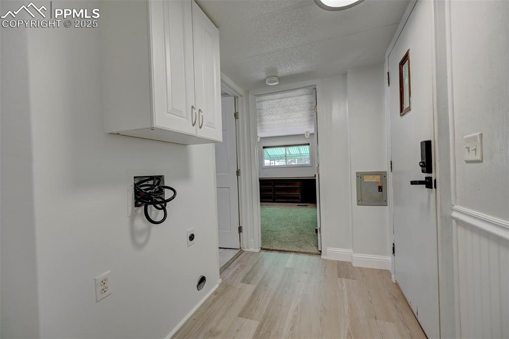 Image 17 of 26: Laundry room featuring cabinet space, hookup for an electric dryer, light w