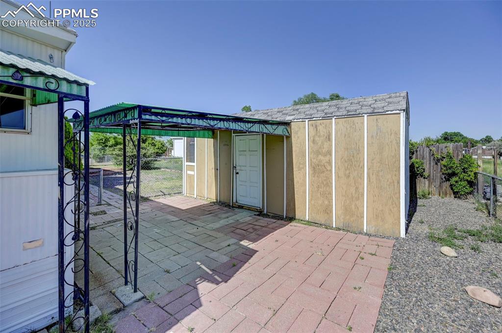 Image 24 of 26: View of patio featuring an outbuilding
