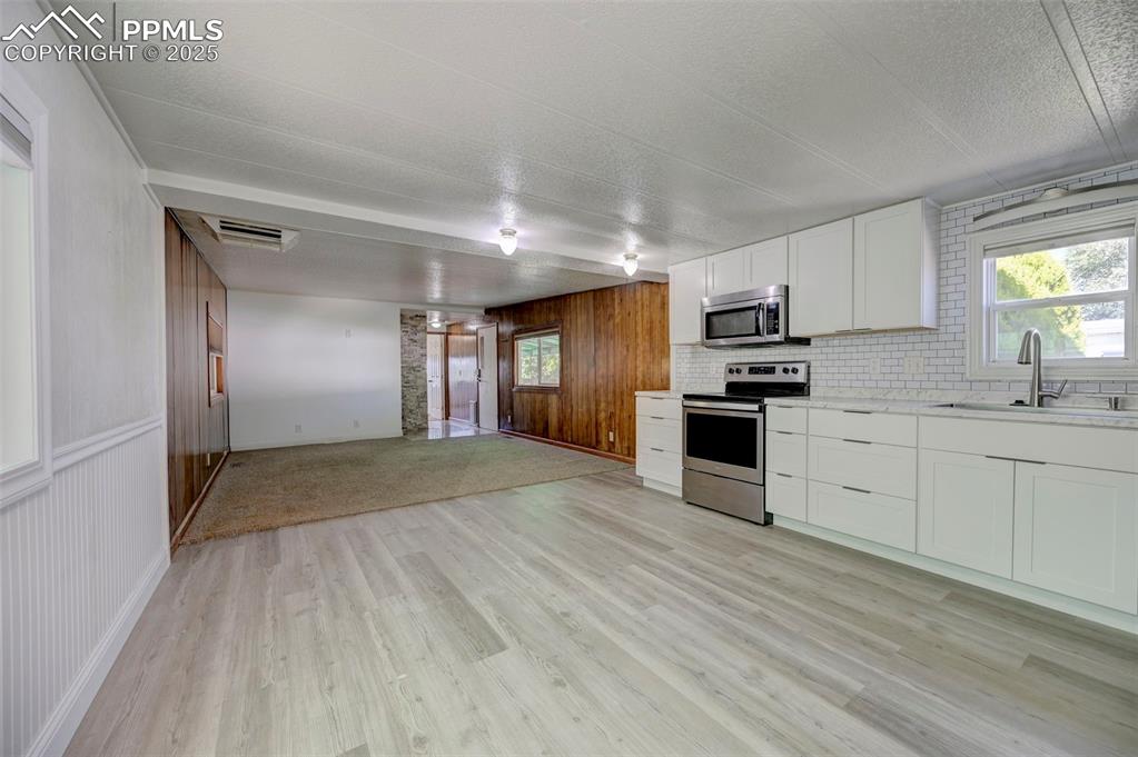 Image 9 of 26: Kitchen with stainless steel appliances, light wood-type flooring, open flo