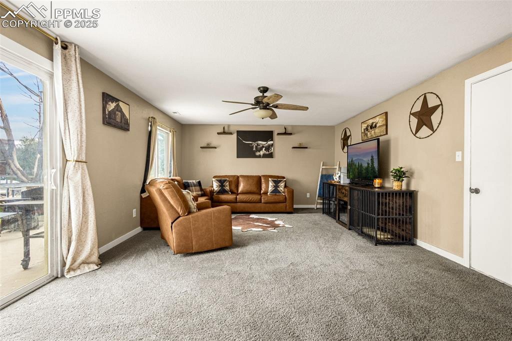 Image 10 of 34: Living area featuring carpet and ceiling fan