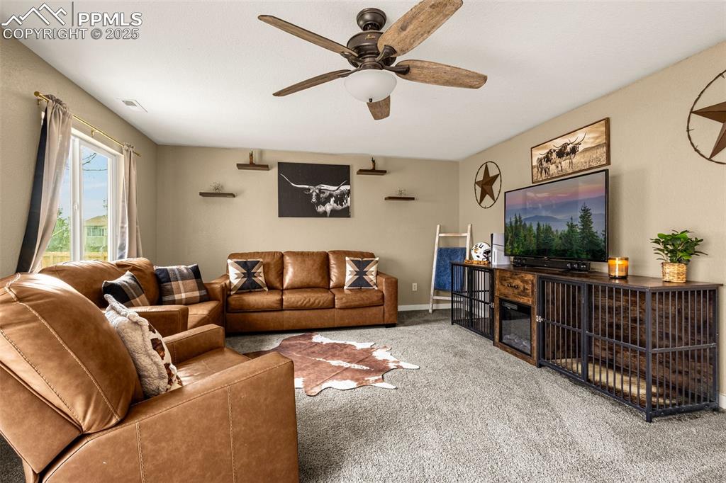 Image 11 of 34: Carpeted living area featuring ceiling fan