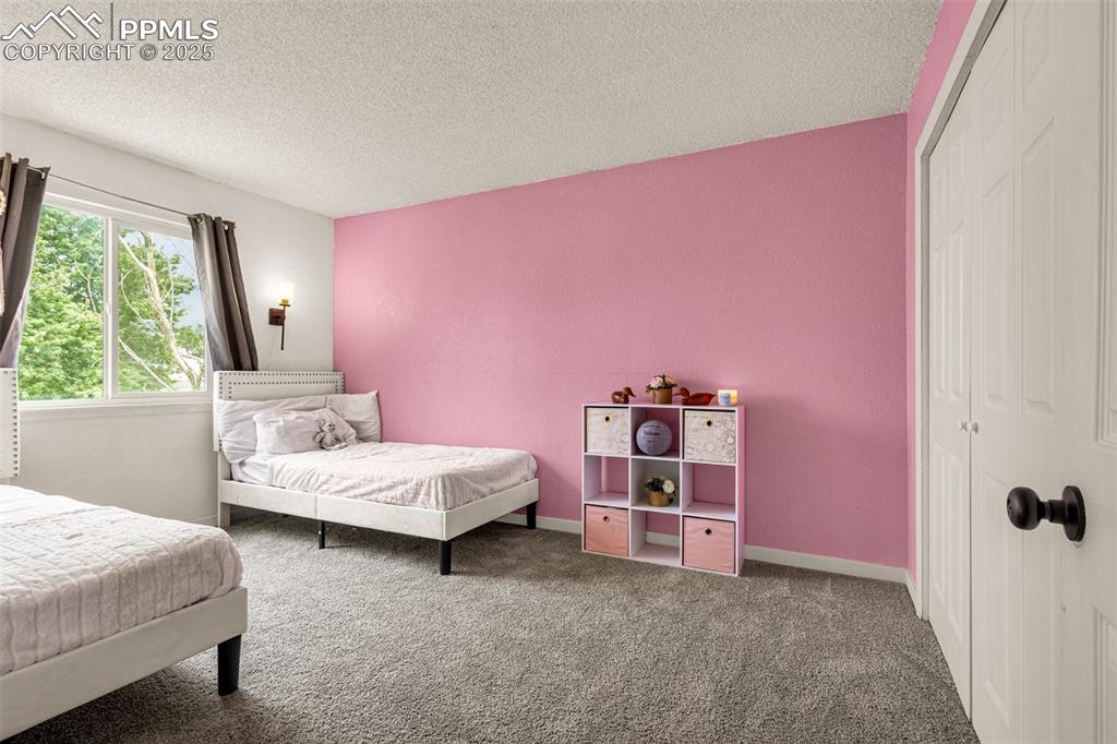 Image 17 of 34: Carpeted bedroom featuring a textured ceiling and a closet