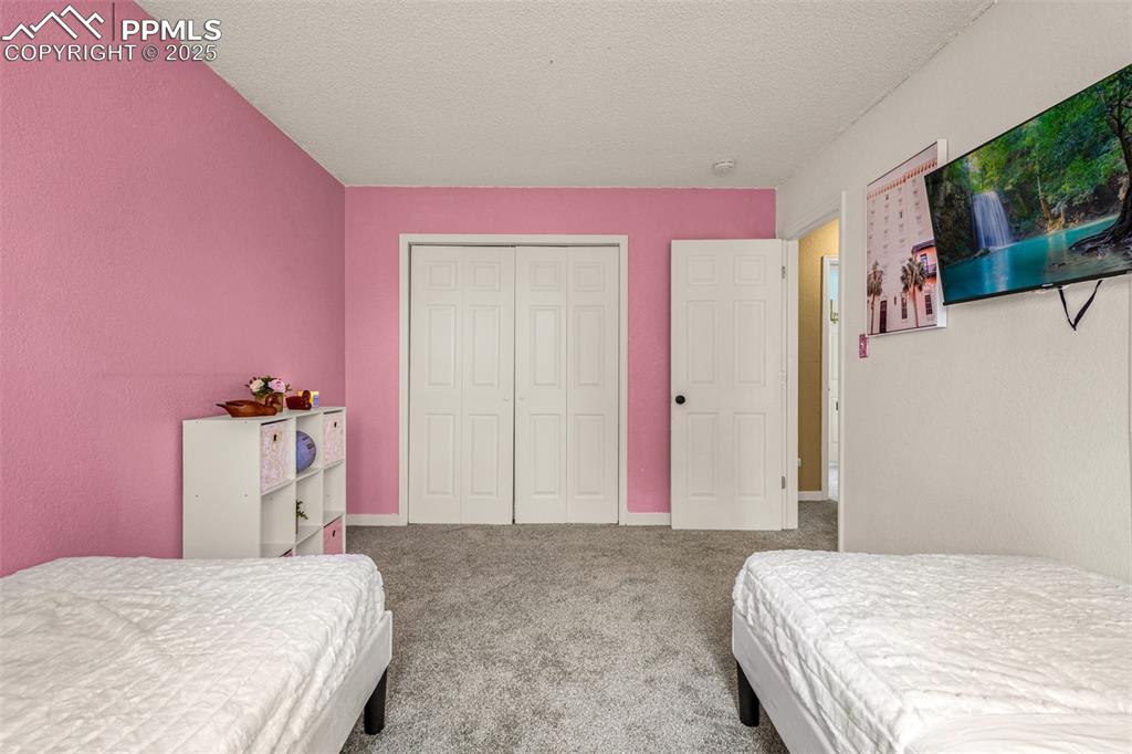 Image 19 of 34: Bedroom with carpet flooring, a textured ceiling, and a closet