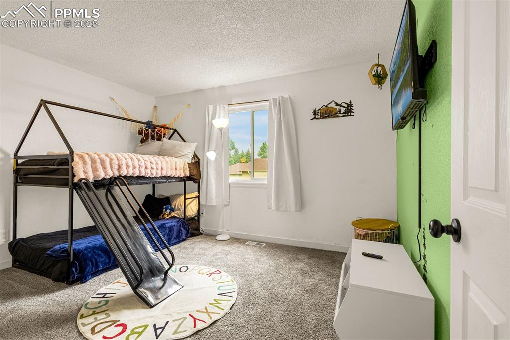 Image 20 of 34: Bedroom featuring carpet flooring and a textured ceiling