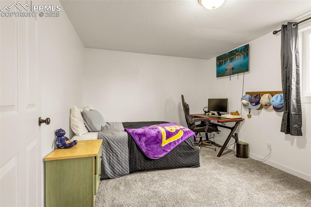 Image 22 of 34: Carpeted bedroom featuring baseboards and an office area