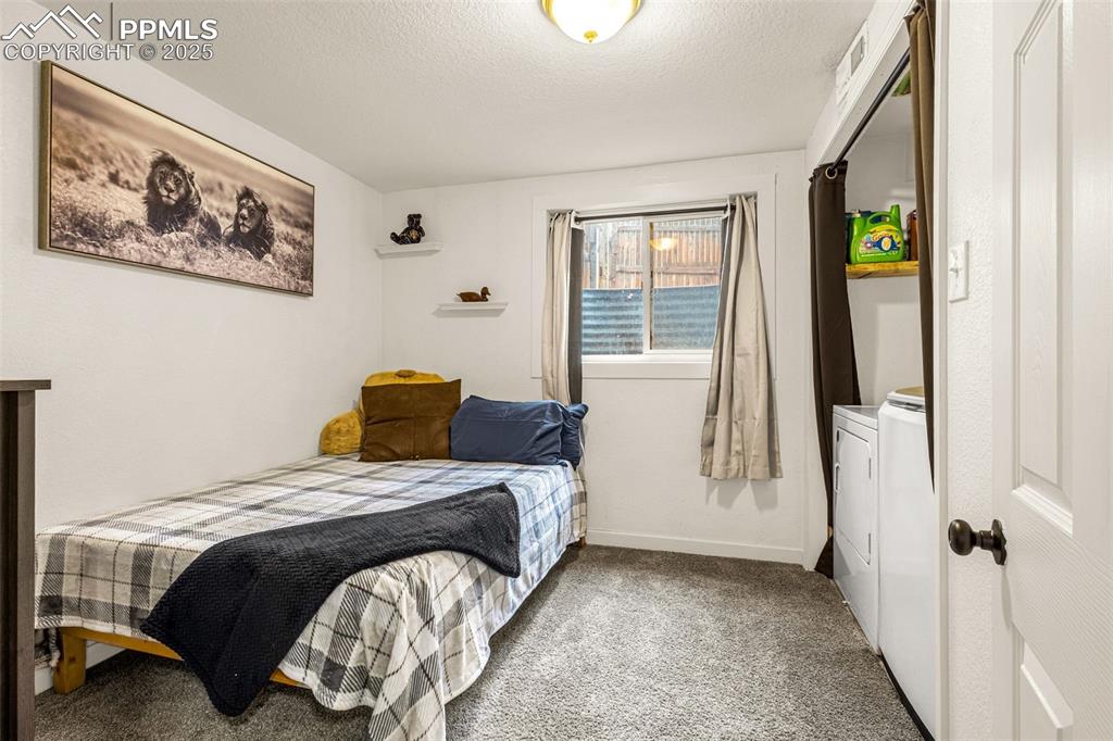 Image 23 of 34: Carpeted bedroom featuring washer / clothes dryer and a textured ceiling