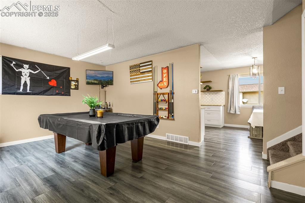 Image 3 of 34: Rec room featuring dark wood-style flooring, a textured ceiling, and billia