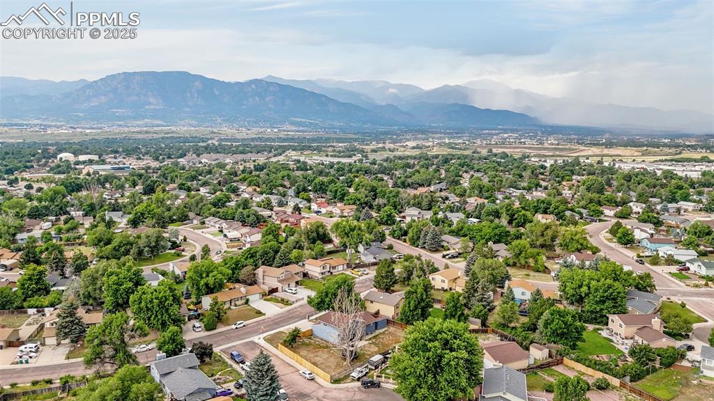 Image 33 of 34: Aerial view of residential area featuring a mountain backdrop