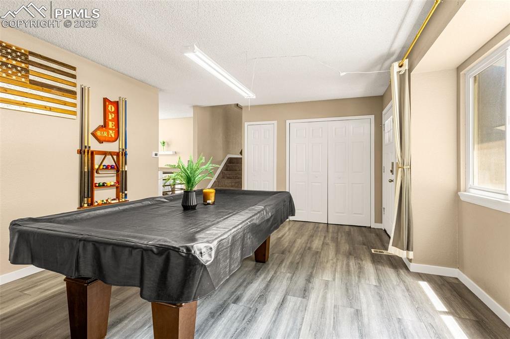 Image 4 of 34: Rec room with wood finished floors, billiards table, and a textured ceiling